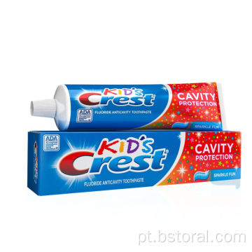 Crianças de crista sorrisos brilhantes com creme dental fluoreto